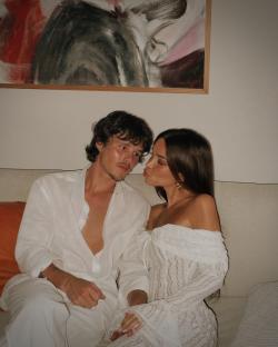 Cruz Beckham and Jackie Apostel cuddling on a couch.