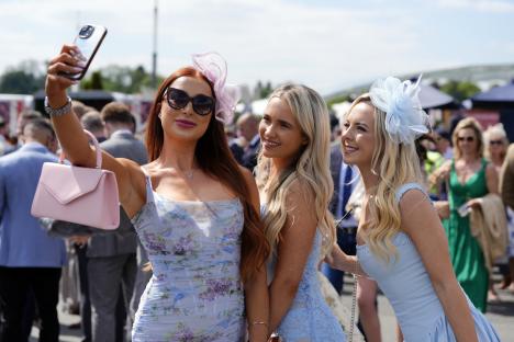 Three women at a racecourse taking a selfie.