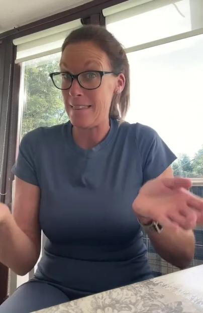 Woman in glasses talking to camera.