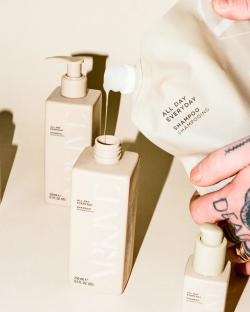 Pouring shampoo from a refill pouch into bottles.