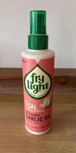 Fry Light 1 Cal Aromatic Garlic Oil cooking spray bottle and a potted plant.