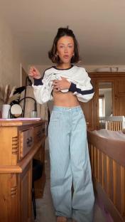 Woman modeling light blue striped jeans.