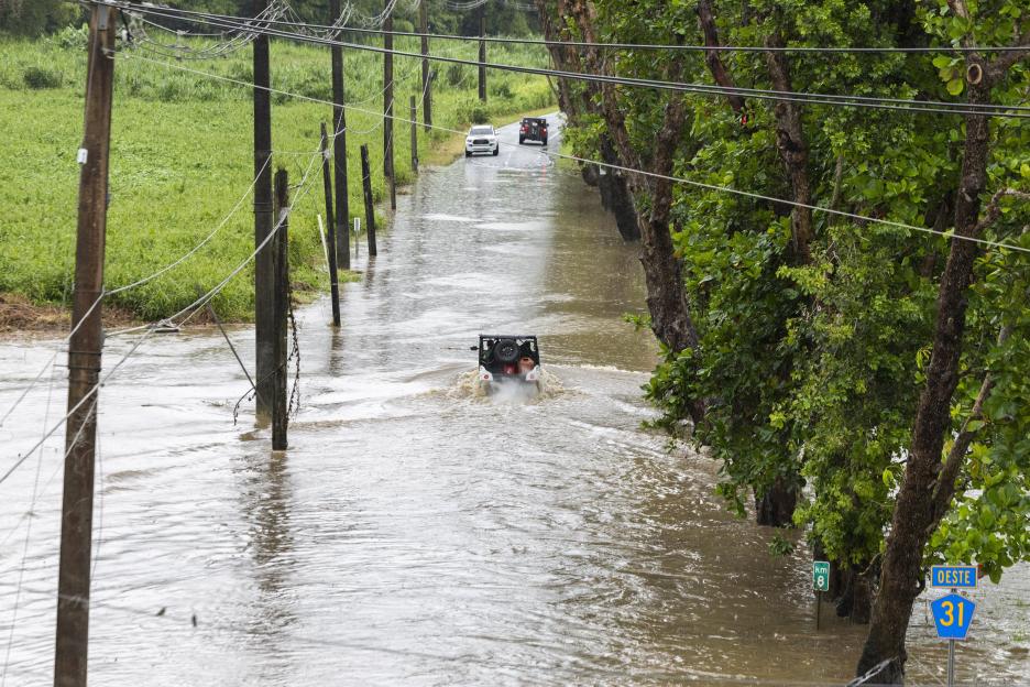 Vehicles driving through a flooded road in Naguabo, Puerto Rico.