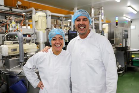 Two smiling workers in a food factory.
