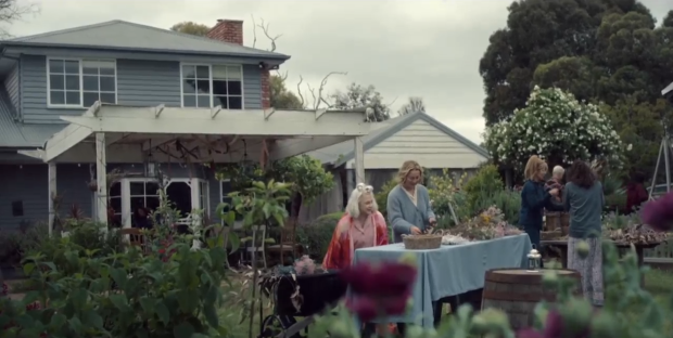 Screenshot of people arranging flowers in a garden.