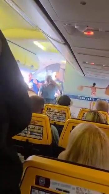 Police removing disruptive passengers from a Ryanair plane.