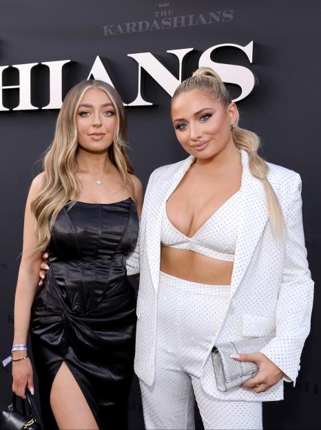 Anastasia Kingsnorth in a black dress and Saffron Barker in a white pantsuit at The Kardashians premiere.