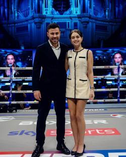 Photo of a man and woman standing in a boxing ring.