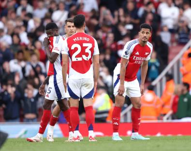 Arsenal and Bournemouth players looking dejected on the field.