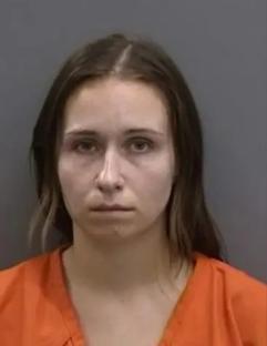 Mugshot of a woman in an orange jumpsuit.