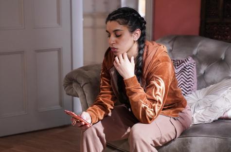 Avani Nandra-Hart looking at her phone.