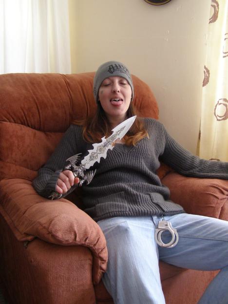 Joanna Dennehy holding a dagger while seated.