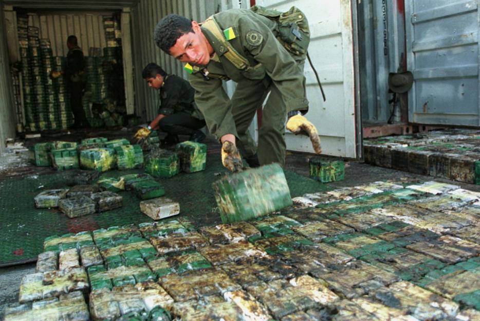 Police officers seizing a large quantity of cocaine.