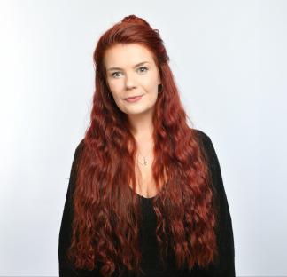 Portrait of a woman with long, curly red hair.