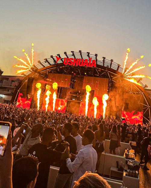 Crowd at Ushuaïa Ibiza enjoying a show with fire effects.