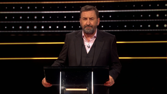 Man in suit at a podium.