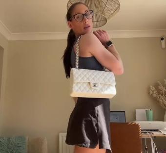 Woman holding a white quilted handbag.