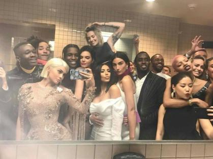 Group selfie of Kylie Jenner, Kendall Jenner, Kim Kardashian, and other celebrities in a bathroom mirror.