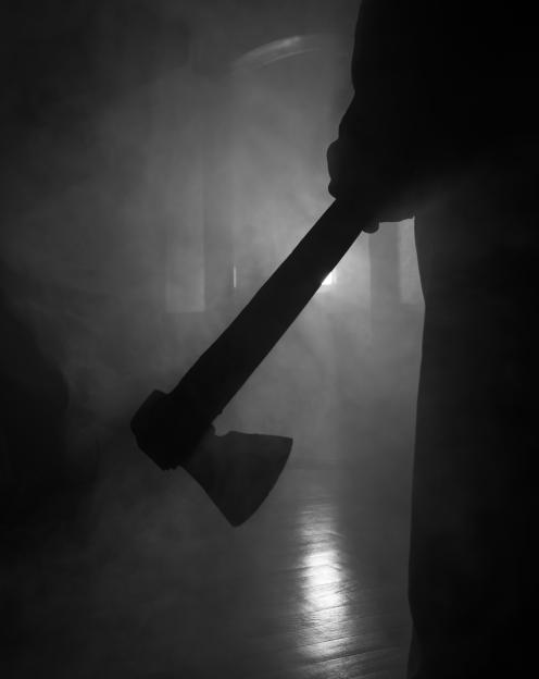 Silhouette of a boy sitting behind a curtain.
