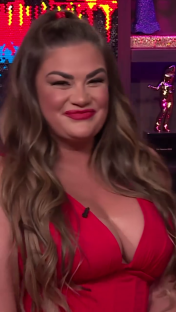 Brittany Cartwright smiling in a red dress.