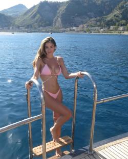Woman in pink bikini on a boat ladder.