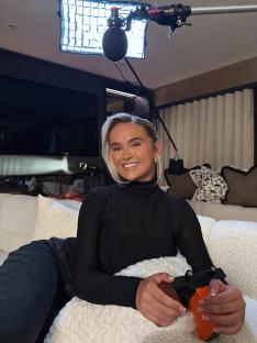 Molly-Mae Hague holding a camera during a film shoot.