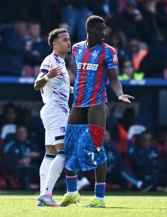 Soccer player with jersey pulled up, arguing with another player.