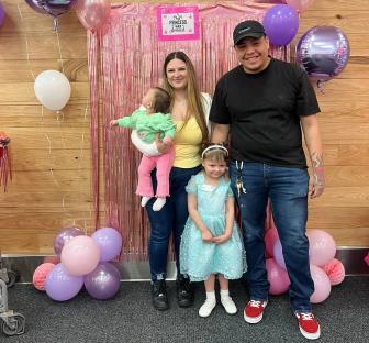 Family portrait in front of a balloon arch.