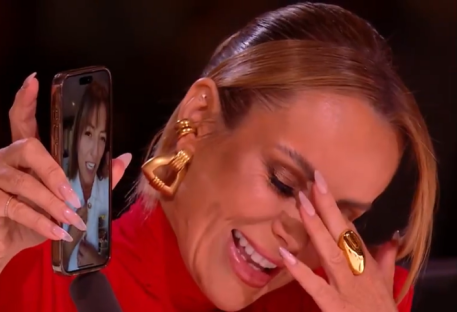 A woman on Britain's Got Talent crying while looking at a video call on her phone.