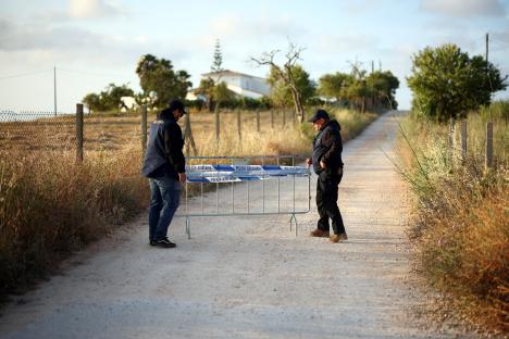 Police officers moving a barrier on a road.