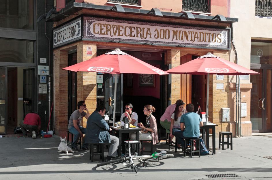 Patrons sitting outside a Cerveceria 300 Montaditos cafe in Seville.