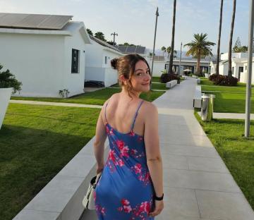 Woman in floral dress walking away from camera.