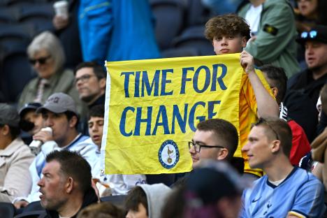 A Tottenham Hotspur fan holds a sign that says "Time for Change."