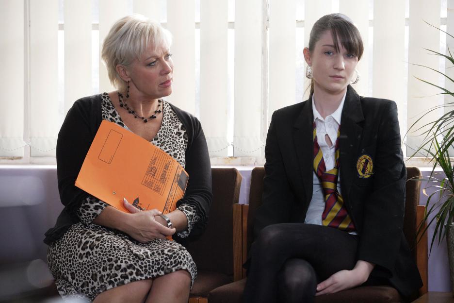 Steph Haydock and Tasha Lefton from the TV series Waterloo Road, sitting, with Haydock holding a file for Lefton.