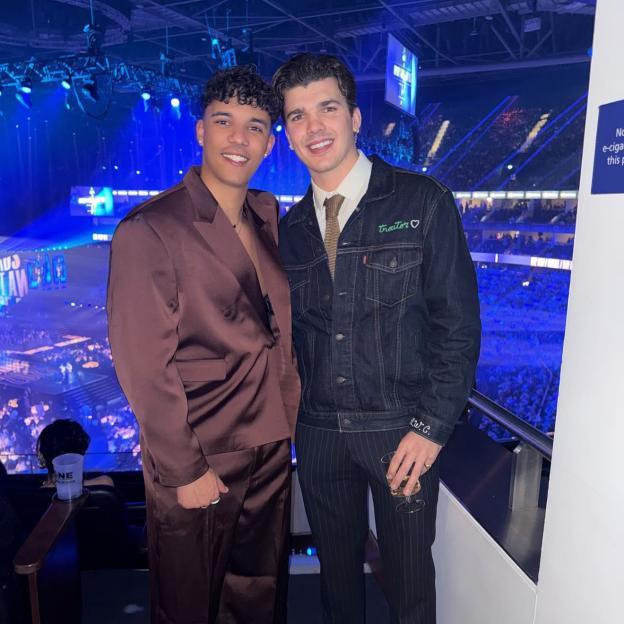 Two men in formal wear at an arena event.