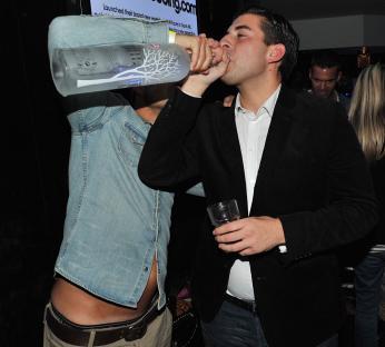 Two men drinking vodka at a nightclub.