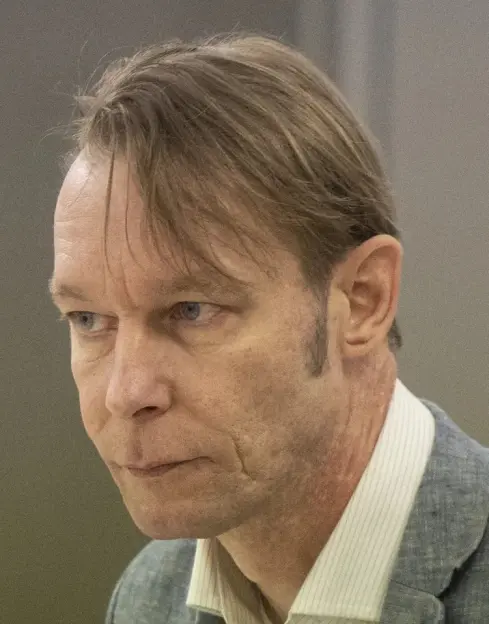Close-up of a man with blue eyes and light brown hair looking to the left.
