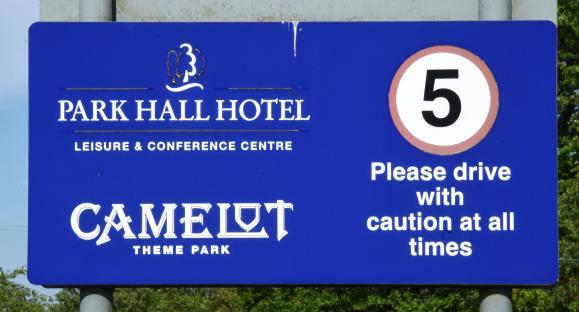 Sign for Park Hall Hotel, Leisure & Conference Centre and Camelot Theme Park; 5 mph speed limit.