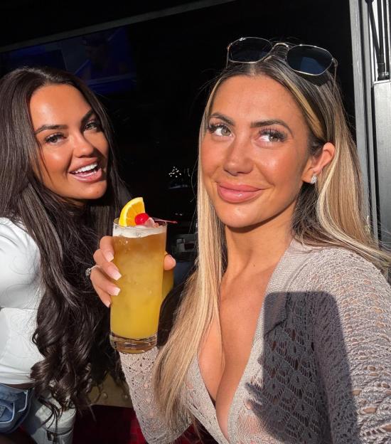 Two women holding cocktails.