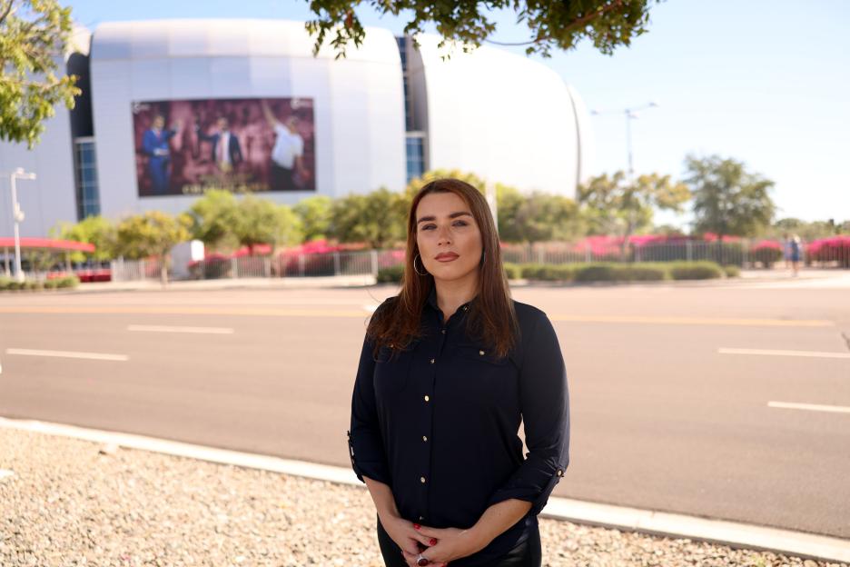 Woman in black shirt standing in front of State Farm Stadium.