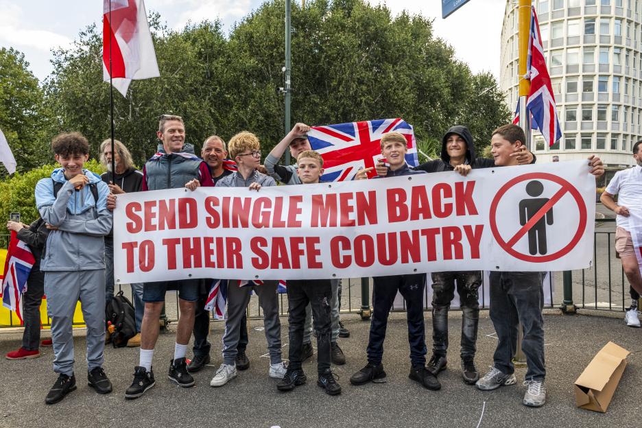 Protestors holding a banner that reads "Send single men back to their safe country".