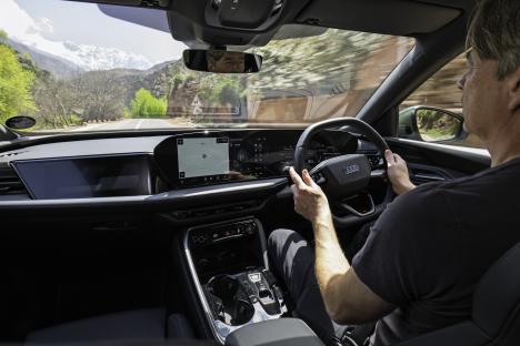 Person driving a car through a mountain pass.