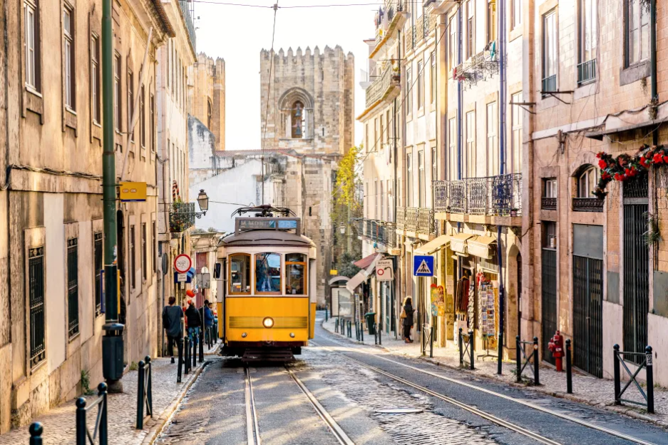 A yellow tram going up a hill in Lisbon, Portugal.