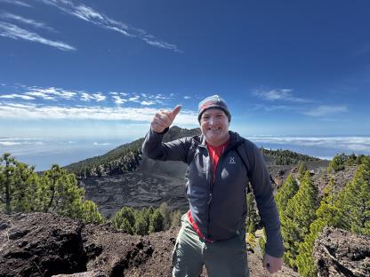 Person giving thumbs up overlooking volcanic landscape in Canary Islands.