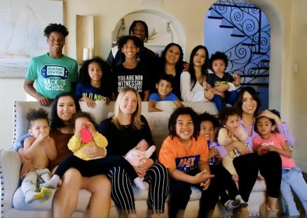 Family photo of a man with his five wives and their children.
