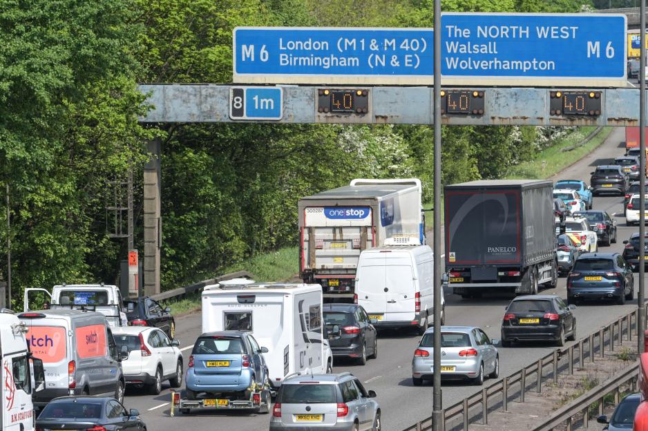 Bank holiday traffic on a motorway with signage for London and The North West, displaying 40 mph speed limits.