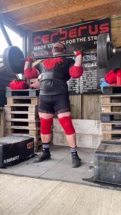 Strongman performing a barbell lift.