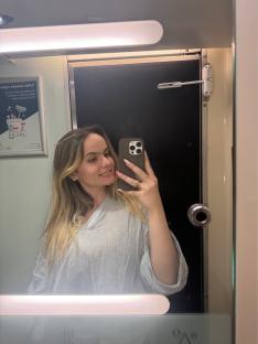 Woman taking a selfie in a train restroom.