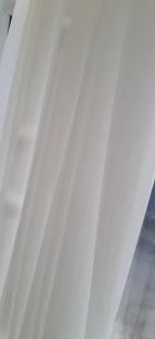 White sheer curtains hanging in front of a window.