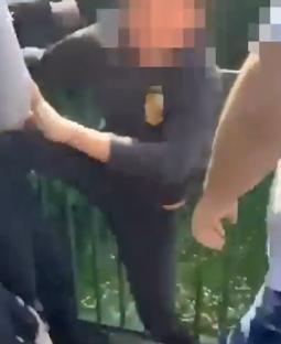 Photo of a person being detained by police.